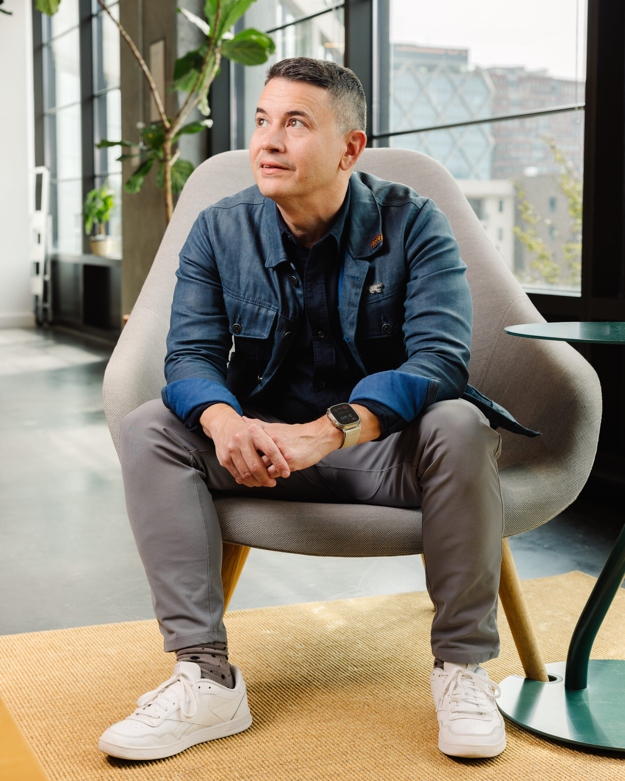 Bobby Kircher sitting in modern office chair, looking up.